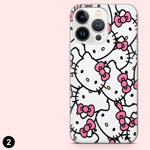 Puede incluir: Una funda transparente para tel&eacute;fono con un patr&oacute;n repetido de caras de gatos de dibujos animados blancos con lazos rosas y contornos negros. La funda tiene recortes para la c&aacute;mara y los botones del tel&eacute;fono.