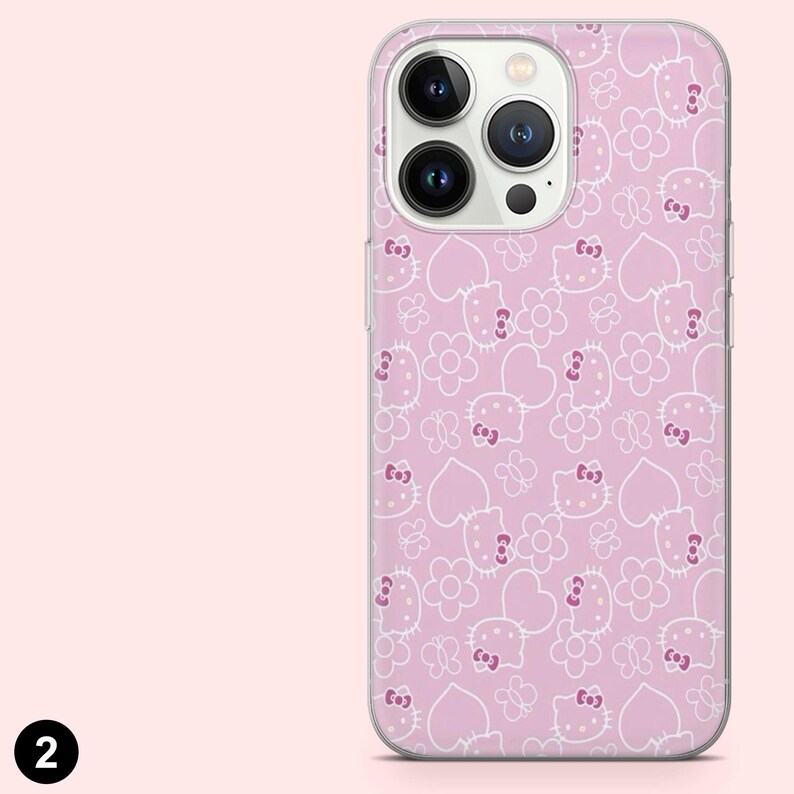 以下が含まれることがあります： ピンク色の携帯電話ケース。白いハローキティの顔、花、ハート、蝶の繰り返し模様。ケースは透明で光沢のある仕上がりで、スマートフォン向けに設計されています。