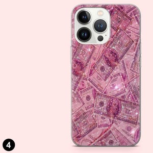 May include: A pink phone case featuring a repeating pattern of pink $100 bills with glitter accents. The case has a clear border and a camera cutout.