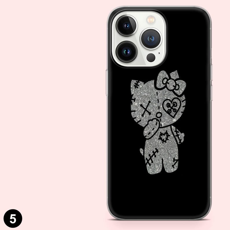 Puede incluir: Funda de tel&eacute;fono negra con un dise&ntilde;o de gato de dibujos animados plateado con purpurina, detalles cosidos, un lazo y un coraz&oacute;n. La funda tiene un borde transparente y un fondo negro. Un accesorio &uacute;nico y llamativo.