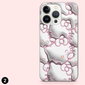May include: A clear phone case with a repeating pattern of white cartoon cat faces with pink outlines and accents. The case has a glossy finish and is designed for a smartphone with multiple camera lenses.