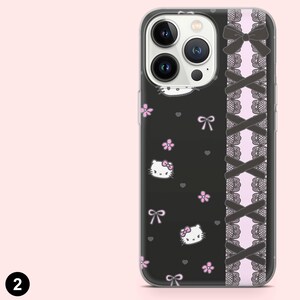 May include: A black phone case featuring a Hello Kitty design with pink flowers and bows. The case has a decorative side panel with black bows and lace over a pink background. The phone case is designed to fit a smartphone.