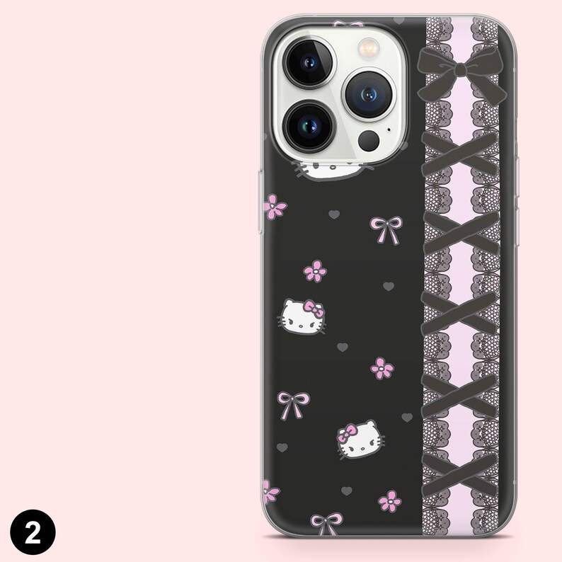 May include: A black phone case featuring a Hello Kitty design with pink flowers and bows. The case has a decorative side panel with black bows and lace over a pink background. The phone case is designed to fit a smartphone.