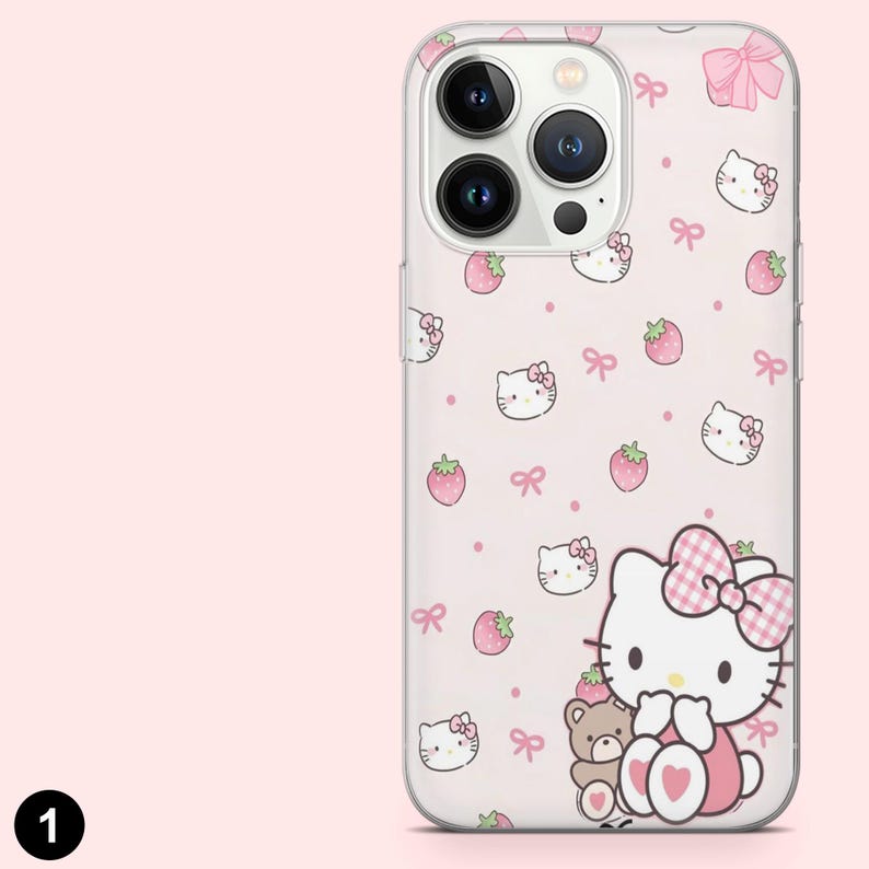 May include: A clear phone case with a pink background featuring a pattern of Hello Kitty faces, strawberries, and bows. The case has a large Hello Kitty character with a teddy bear. The case is designed for a smartphone.