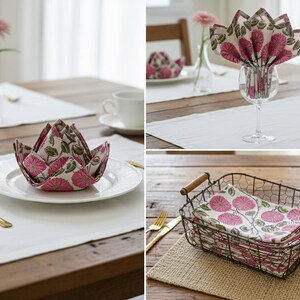 May include: Floral print napkins displayed in different ways on a wooden table. One is folded into a flower shape on a plate, another is in a wine glass, and others are stacked in a wire basket. A gold spoon and a flower in a vase are also visible.