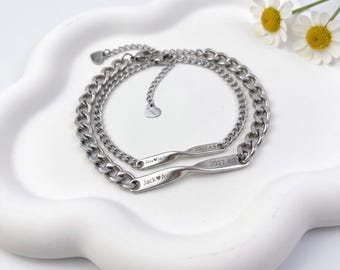 May include: Two silver-toned metal chain bracelets featuring a central twisted bar element. One bar is engraved with 'Ava heart Jack' and '2022.4.8', while the other displays 'Jack heart Ava' and '2022.4.8'. Each bracelet includes a small heart charm.