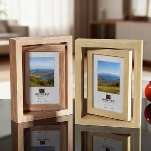 May include: Two wooden photo frames, one light brown and one beige, each with a smaller frame inside. The frames display a landscape image. The text "HONGBO PHOTO FRAME 4in x 6in 10cm x 15cm" is visible on the frames.