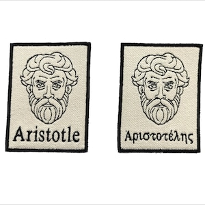 Pode incluir: Dois patches de tecido branco com contornos pretos. Os patches apresentam um desenho de linha do rosto de Aristóteles e o texto "Aristotle" e "Αριστοτέλης".