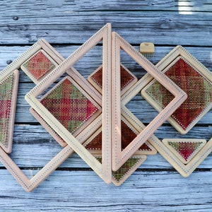 May include: A set of wooden weaving looms in various sizes, with woven squares and triangles in red, green, and brown.