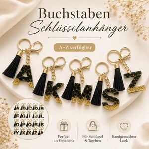 Könnte beinhalten: Goldfarbene Schlüsselanhänger mit schwarzen Quasten und Buchstaben A, K, M und S im Leopardenmuster. Die Buchstaben haben eine goldene Glitzerbasis. Das Bild zeigt auch eine Tabelle mit verfügbaren Buchstaben und Symbolen.
