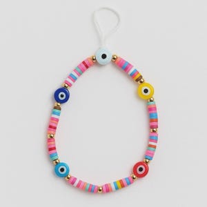 Op de afbeelding: Een kleurrijke kralenarmband met oogvormige bedels. De armband bestaat uit roze, blauwe, gele en rode kralen, afgewisseld met goudkleurige accenten. Aan de bovenkant van de armband is een wit touwtje bevestigd.