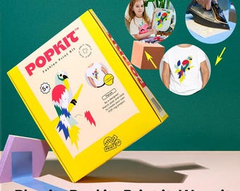 May include: A yellow POPKIT Fashion Print Kit box with a parrot design. The kit includes instructions and materials for creating custom printed apparel. The text on the box reads "Plan it. Peel it. Print it. Wear it."