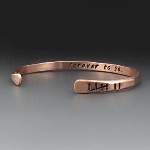 May include: A copper bracelet with the words "forever to go." engraved on the outside and the initials "LHH II" engraved on the inside.