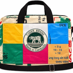 Peut inclure: Un sac pour ordinateur portable rectangulaire en plastique tissé recyclé avec un patchwork de panneaux jaunes, blancs, bleus, verts et roses. Un logo circulaire central indique TIGIER BRAND Made in Cambodia avec un tigre. Sangles noires.