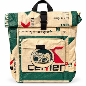 Op de afbeelding: Een roll-top rugzak gemaakt van gerecycled geweven materiaal in een crème, groene en rode kleurstelling. De voorzijde toont een cirkelvormig logo met een tijgerillustratie en de tekst "cement". Het heeft een zwarte gespsluiting.