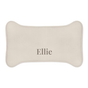 Peut inclure: Coussin pour chien en forme d'os, de couleur beige clair. Le nom "Ellie" est imprim&eacute; en gris. Ce coussin est con&ccedil;u pour le confort et le soutien des animaux de compagnie.