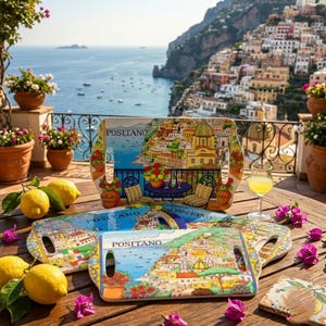 Può includere: Tre vassoi da portata rettangolari con una colorata illustrazione della costa di Positano e la scritta Positano. I vassoi sono dotati di manici integrati e sono decorati con vivaci scene costiere, tra cui edifici, il mare e fiori.