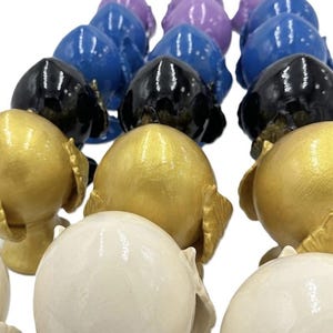 Könnte beinhalten: Ein Set aus drei Keramikbechern mit gesprenkelter, matter Oberfläche. Jeder Becher hat eine andere Farbe: hellblau, cremefarben und grau. Die Becher haben ein schlichtes, modernes Design und einen bequemen Griff.