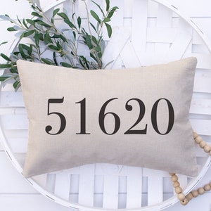 May include: A beige linen pillow with the number 51620 printed in black.