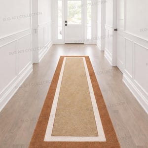 Puede incluir: Una alfombra rectangular para pasillo con borde marrón, borde interior crema y centro beige. La alfombra está colocada sobre un suelo de madera clara en un pasillo con paredes y puertas blancas.
