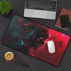 May include: A rectangular mousepad featuring a digital art portrait in shades of red, black, and teal. The artwork depicts a character with a patch over one eye. A white computer mouse sits on the pad, with a laptop and notepad in the background.