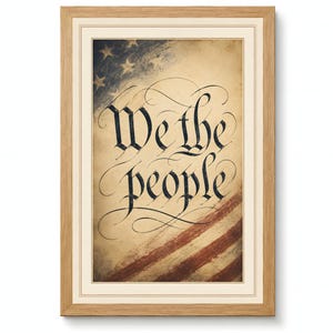 Może przedstawiać: Oprawiony wydruk z kaligraficznym napisem „We the people”. Tło przedstawia wyblakłą amerykańską flagę z gwiazdami i pasami. Wydruk jest oprawiony w jasnobrązową drewnianą ramę.