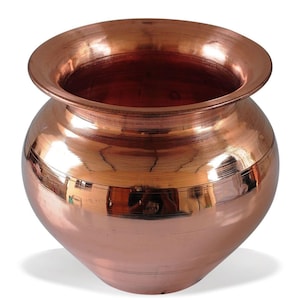 Puede incluir: Una olla redonda de color cobre con un borde ancho y acampanado. La olla tiene un cuerpo bulboso y una superficie pulida y reflectante. El interior de la olla es de un tono más oscuro de cobre. Esta olla decorativa es adecuada para varios usos.