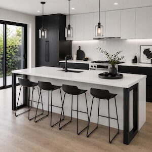 May include: Modern kitchen with a white countertop island and black bar stools. The kitchen features black cabinetry, a black faucet, and pendant lights. A black refrigerator and a sliding glass door are also visible.