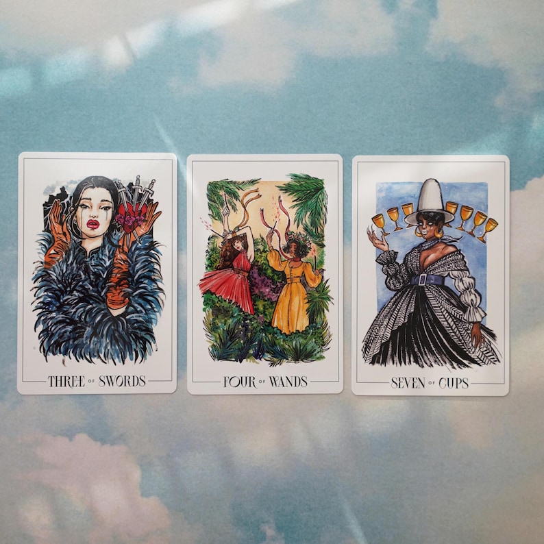 May include: Three tarot cards with watercolor illustrations. The first card is the Three of Swords, depicting a woman in a blue feathered coat with three swords piercing a heart. The second card is the Four of Wands, showing two women in a forest setting, one in a red dress and the other in a yellow dress. The third card is the Seven of Cups, featuring a woman in a black and white dress with a white hat, holding seven cups.
