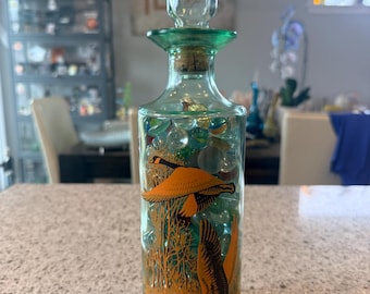 Frasco decantador de vidrio verde estilo boticario antiguo, lleno de canicas y vidrio surtidos.