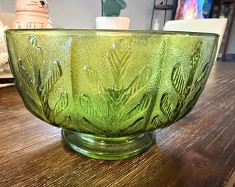 Compotera con base, de vidrio verde prensado con diseño de hoja, de la marca FTD, año 1975.