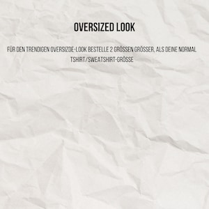 May include: A white, textured, crumpled paper background featuring black text that reads OVERSIZED LOOK followed by F&Uuml;R DEN TRENDIGEN OVERSIZDE-LOOK BESTELLE 2 GR&Ouml;SSEN GR&Ouml;SSER, ALS DEINE NORMAL TSHIRT/SWEATSHIRT-GR&Ouml;SSE in the center of the image.