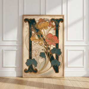 Könnte beinhalten: Gerahmter Kunstdruck mit einem tealfarbenen Buchstaben "N" und floralen Details in Gelb, Pfirsich und Weiß. Das Kunstwerk im Vintage-Stil ist vor einem cremefarbenen Hintergrund und in hellem Holz gerahmt.
