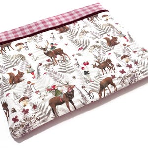 May include: A rectangular zipped pouch featuring a white fabric base with a repeating pattern of brown deer, squirrels, mushrooms, ferns, and small figures in red hats. The top edge has a pink and white gingham fabric border with a metal zip.