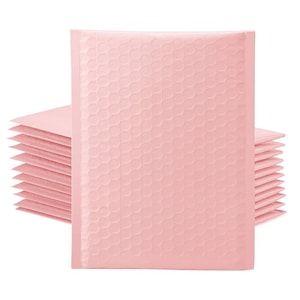 May include: A stack of light pink bubble mailers. The mailers have a textured, bubble-wrap-like surface. The bubble mailers are designed for shipping small items and are shown against a white background.