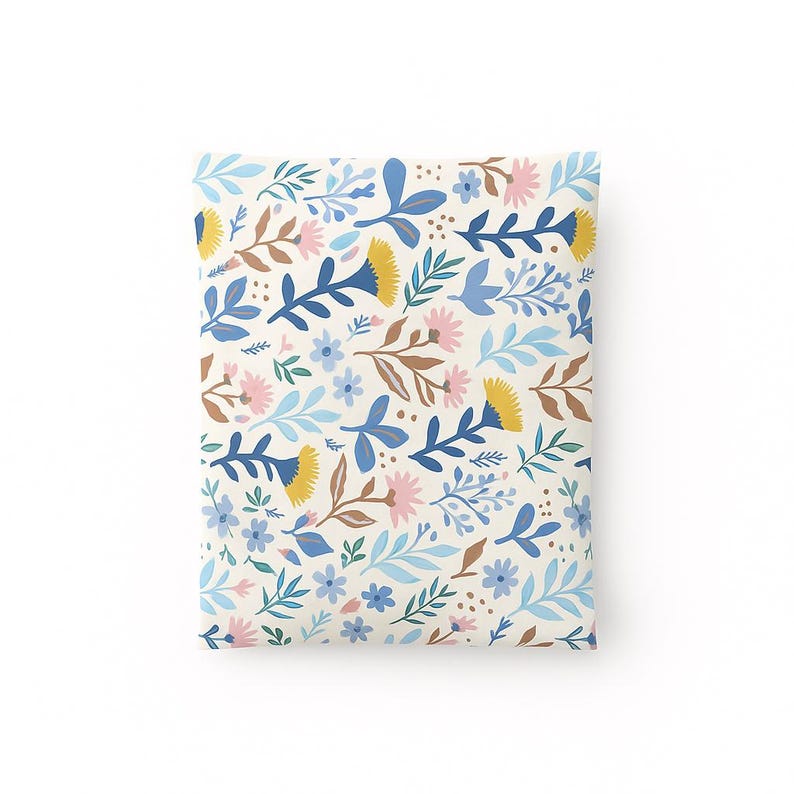 May include: A square pillow with a floral pattern. The design features blue, yellow, pink, and brown flowers and leaves on a cream background. The pillow is likely for home decor.