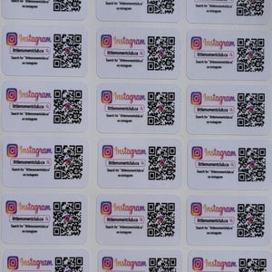 May include: A sheet of white, rectangular stickers with rounded corners. Each sticker displays the Instagram logo, a QR code, and the text "littlemomentclub.ca". The text "Search for 'littlemomentclub.ca' on Instagram" is also present.