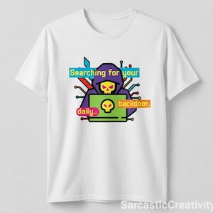 Może przedstawiać: Biała koszulka z kolorową grafiką przedstawiającą postać w kapturze z czaszką pracującą na laptopie. Tekst na koszulce brzmi "Searching for your backdoor, daily..". Projekt ma motyw techniczny i cyberbezpieczeństwa.