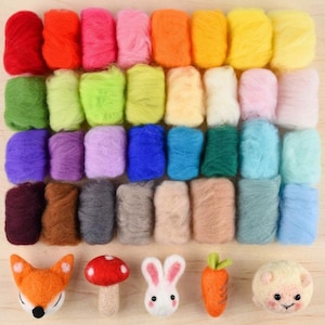 May include: A collection of forty rectangular bundles of colorful wool roving arranged in a grid, accompanied by five needle-felted figures: a fox face, a red mushroom, a white rabbit face, an orange carrot, and a round cream-colored animal face.