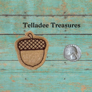 May include: A brown felt acorn applique with a brown embroidered cap. The acorn is about the size of a US quarter.