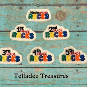 May include: Five colorful felt patches with the words "Kindergarten Rocks", "1st Grade Rocks", "2nd Grade Rocks", "3rd Grade Rocks", and "5th Grade Rocks".