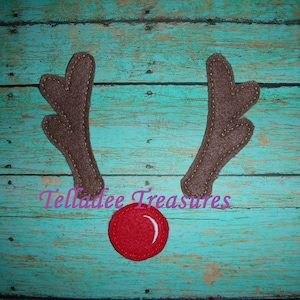 May include: Felt reindeer antlers with a red felt nose. The antlers are brown with a stitched edge. The nose is a simple circle.