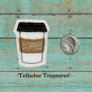 May include: A white felt coffee cup applique with a brown felt label that says "COFFEE" in white embroidery. The applique is approximately the size of a US quarter.