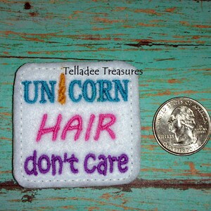 May include: White felt patch with colorful embroidered text that reads "Unicorn Hair don't care". The patch is about the size of a US quarter.