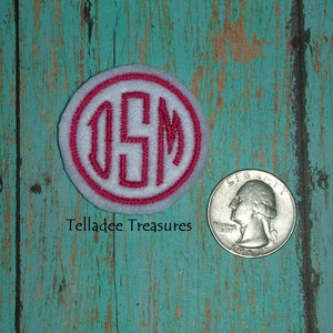 May include: White felt circle with a red outline and the letters "DSM" embroidered in red.