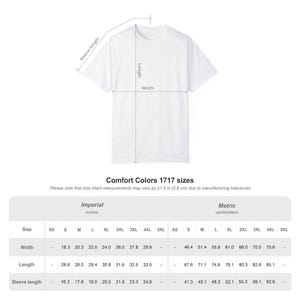 Op de afbeelding: Wit T-shirt met afmetingen voor breedte, lengte en mouwlengte. De maattabel bevat imperiale maten in inches en metrische maten in centimeters. De tekst "Comfort Colors 1717 sizes" is ook aanwezig.