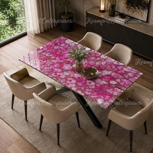 May include: A rectangular dining table featuring a vibrant pink agate stone tabletop with a polished finish, supported by a black metal base. The table is surrounded by four beige upholstered chairs with curved backrests and dark wooden legs.