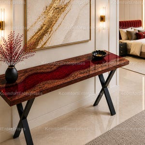 May include: A rectangular console table with a dark wood finish and a red resin river design. The table has black metal legs and is decorated with a black vase and a decorative bowl. The table is 60 inches long.