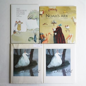 May include: Four children's books are displayed. The titles include "The Deliverers of Their Country", "Noah's Ark", and two copies of "Swan Lake". The covers feature illustrations of characters and scenes from the stories, with a variety of colors and styles.