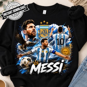 May include: A black sweatshirt featuring a graphic print of Lionel Messi in an Argentina soccer jersey, the AFA logo, a bald eagle, a soccer ball, and a sun emblem. The text MESSI is printed in large white letters with a gold crown icon above it.